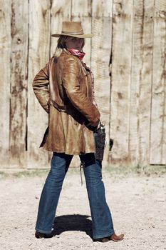 Portrait of a blond cowgirl with hand on the gun