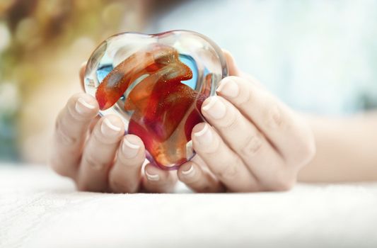 Woman hands holding heart shape object