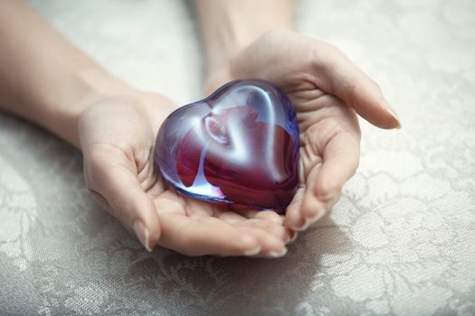 Woman hands holding heart shape object