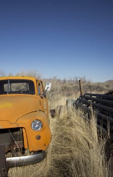 an old abandoned orange truck in the farm lands.