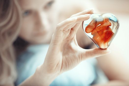 Woman hands holding heart shape object