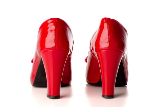 Red shoes isolated on white reflective background.
