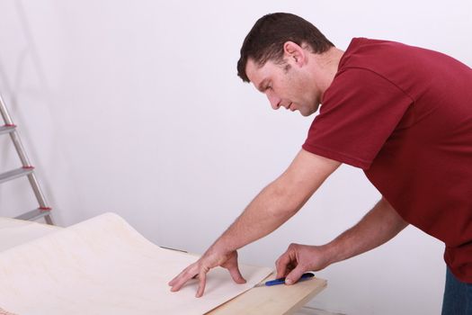 Tradesman cutting a sheet of paper