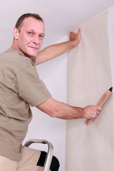 Man hanging wallpaper
