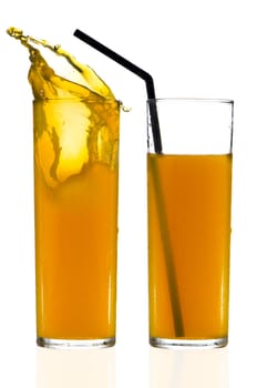 Two cups of orange juice over white reflective background.