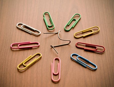 Paper clips on wood background illustrating a unique concept
