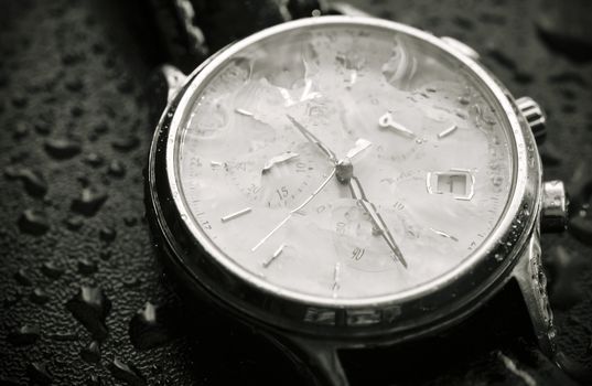 Wristwatch covered with rain drops