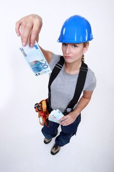 Female electrician holding bank-notes
