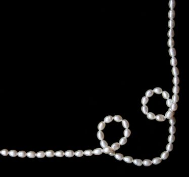 White pearls on the black velvet background 