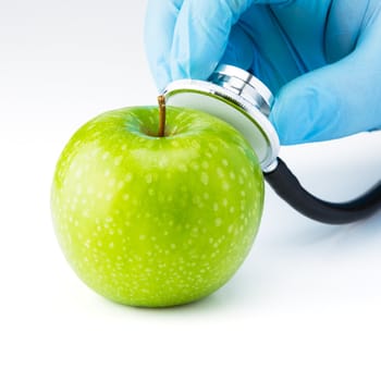 Green Apple Granny Smith with medical stethoscope signifying healthy eating