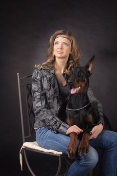Woman with dobermann dog on black background
