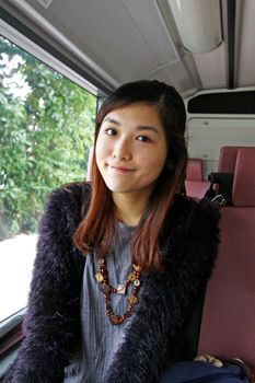 Asian woman in the bus and smiling