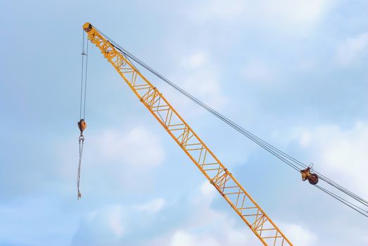 Metal construction crane on a background of blue sky