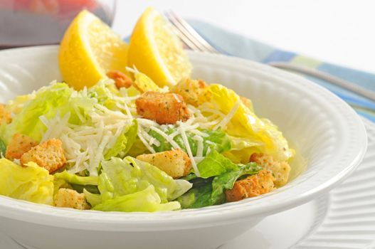Delicious caesar salad served with wedges of lemon.