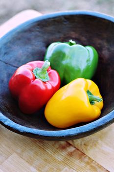 Colorful peppers in a hand carved wooden bowl