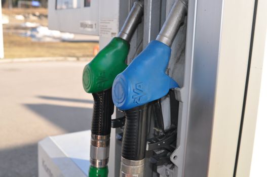 A couple of fuel nozzles at a gas station.