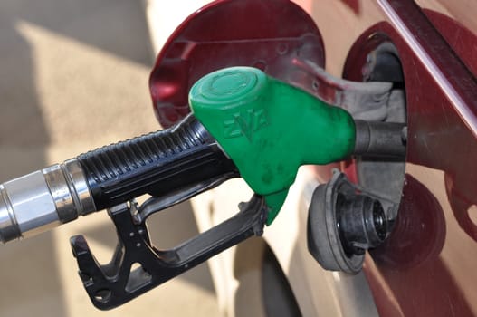 Filling up a cars gastank with unleaded petroleum.