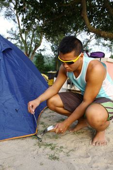 Asian man set up tent in camping