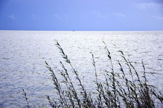 Calm sea sky landscape ship sailing in distance.