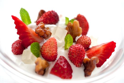 Macro Close up of yogurt ice cream dessert with strawberries and caramelized nut dressing
