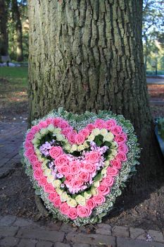 Heart shaped sympathy flower arrangement with pink roses