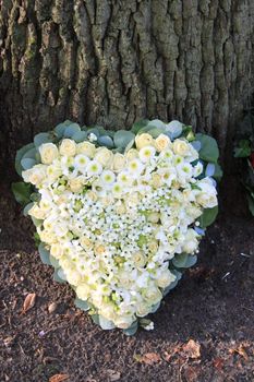 Heart shaped sympathy flower arrangement with white flowers