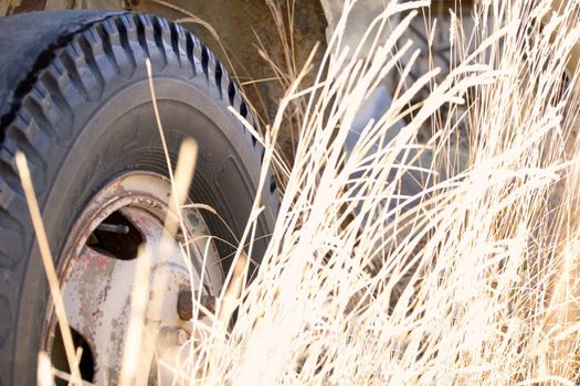 Tire and wheel well of forgotten truck in the tall grass