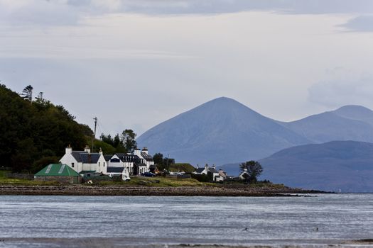 small housing estate at the sea in north scotland with mountains in background