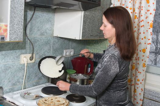 A woman preparing lunch - pancakes bake
