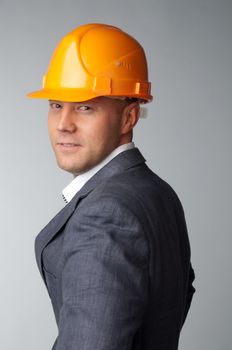 Portrait of a handsome middle-aged man in a yellow construction helmet and a business suit