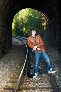 Cool guitarist portrayed inside a railway tunnel