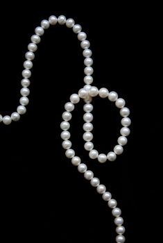 White pearls on the black velvet background 