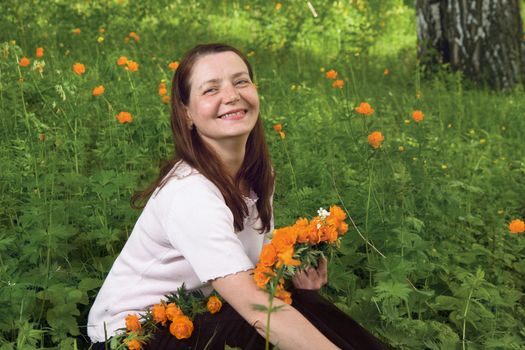 Woman with flowers in a forest glade