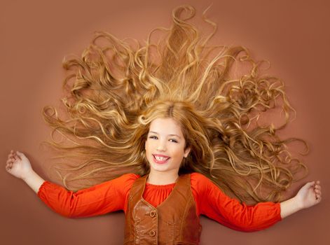 autumn fall little blond girl on brown background and long spreaded hair