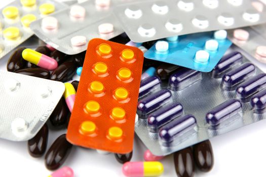 Pills of many shapes and colors grouped together.