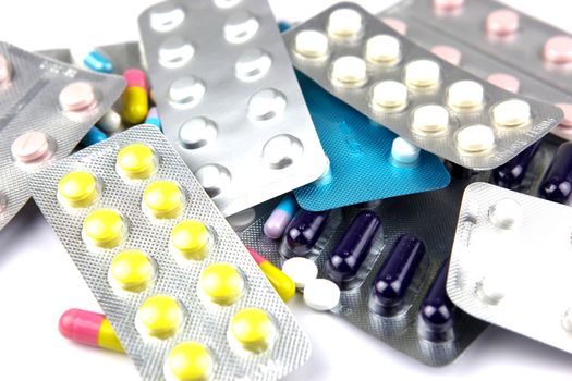 Pills of many shapes and colors grouped together.