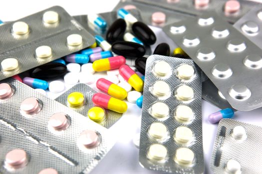 Pills of many shapes and colors grouped together.