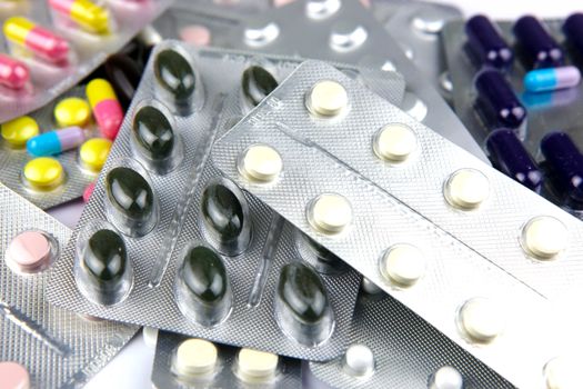 Pills of many shapes and colors grouped together.