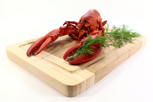 a lobster with dill on a wooden board