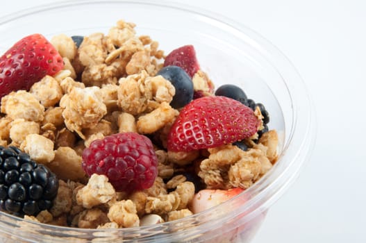 A bowl with yogurt, granola and fruits.