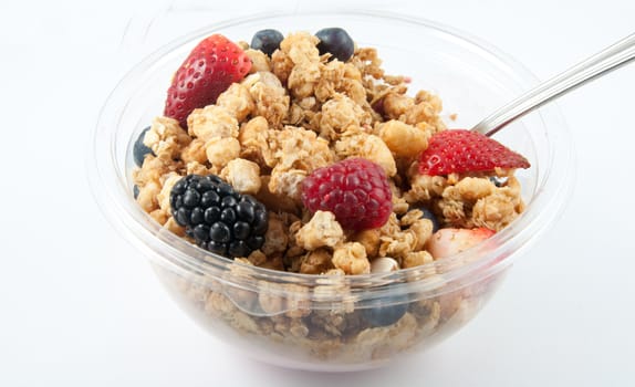 A bowl with yogurt, granola and fruits.