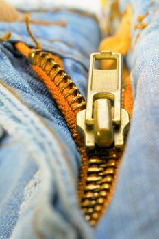 Zipper on the blue indigo jeans. Macro photo.