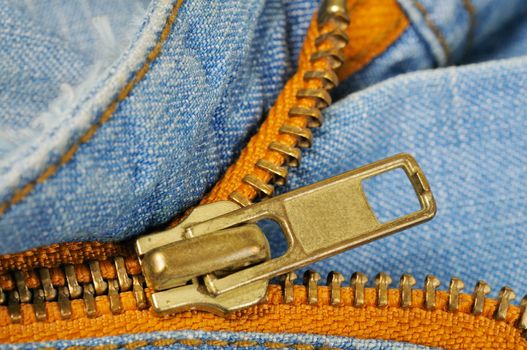 Zipper on the blue indigo jeans. Macro photo.