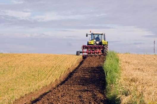 Tractor plowing of agricultural field. Maintenance of land after harvest.