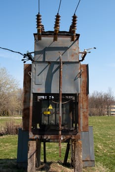 old rusty high voltage transformer in the countryside