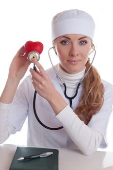 Female docotr examining red heart with stethoscope isolated on white