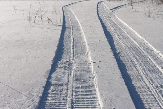 Traces of a snowmobile on a white snow