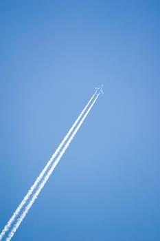 White airplane trace on blue sky

