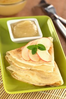 Crepes with apple slices and apple sauce (Selective Focus, Focus on the mint leaf)