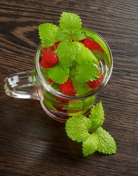 Raspberry Beverage with Perfect Fresh Lemon-Balm Leafs in Glass Cup on Dark Wooden background. Top View